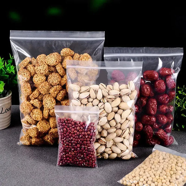 Several clear ziplock bags filled with various dried seeds and grains like pumpkin seeds flax seeds and red beans