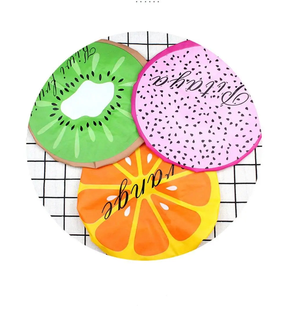 Three reusable fruit shower caps featuring kiwi, strawberry, and orange designs on a white background.