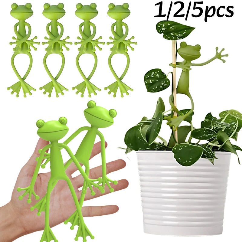Green frog shaped plant support and vine holder with five pieces shown alongside a potted plant