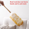 A hand is holding a yellow and white fluffy broom made of real wool, emphasizing that it does not harm hands and is anti-stat