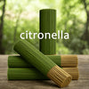 A stack of green citronella oil sticks, some lying horizontally on a wooden surface.