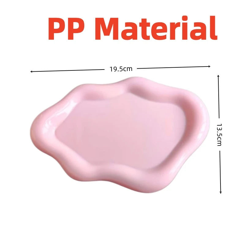 A pink PP material jewelry organizer tray with a slightly wavy edge.
