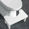 A white portable bamboo toilet squat stool with a seat and stand is shown on a gray tiled floor.