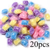 A collection of colorful laundry fragrance beads in various shades of purple, blue, and yellow.