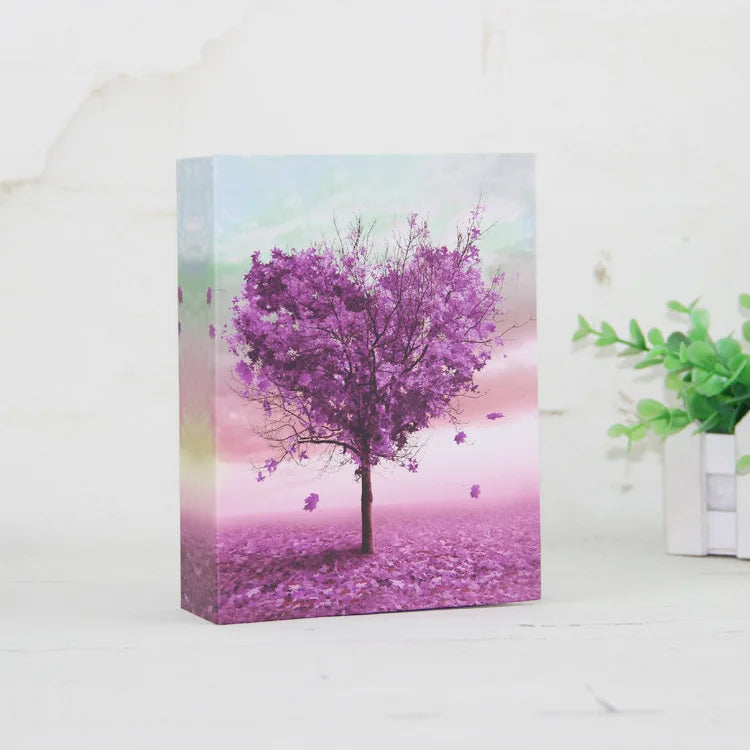 Álbum vertical con un vibrante árbol morado contra un fondo de atardecer rosa.