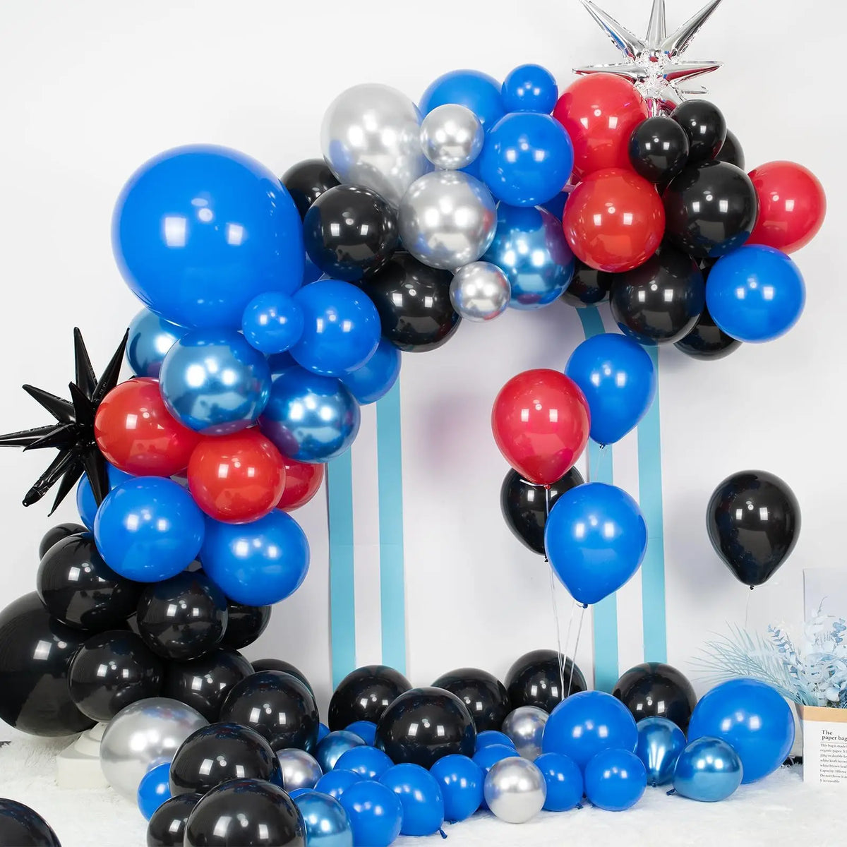 A balloon garland kit featuring blue, red, and black balloons arranged in an arc against a white background.
