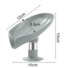 A gray leaf-shaped suction cup soap holder with a self-draining tray and a cylindrical base.