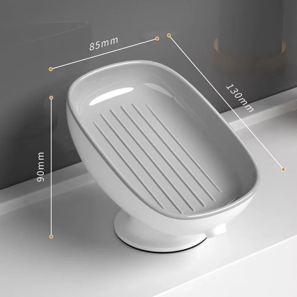 A white suction cup soap dish with built-in drainage features and a slatted tray shown in profile.