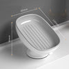 A white suction cup soap dish with built-in drainage features and a slatted tray shown in profile.