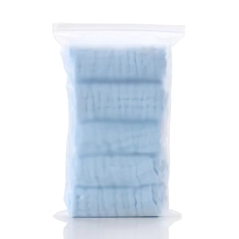 Paquete de plástico transparente con 5 toallitas orgánicas de algodón para bebé y cara de color azul claro.