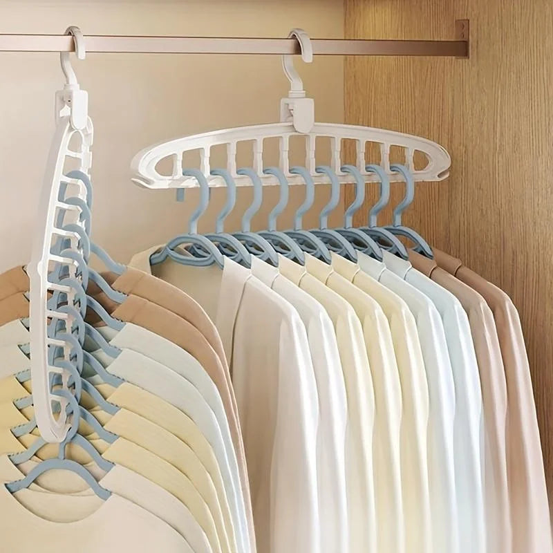 A white multi-hole laundry drying rack with light blue hangers hanging on a wooden rod.