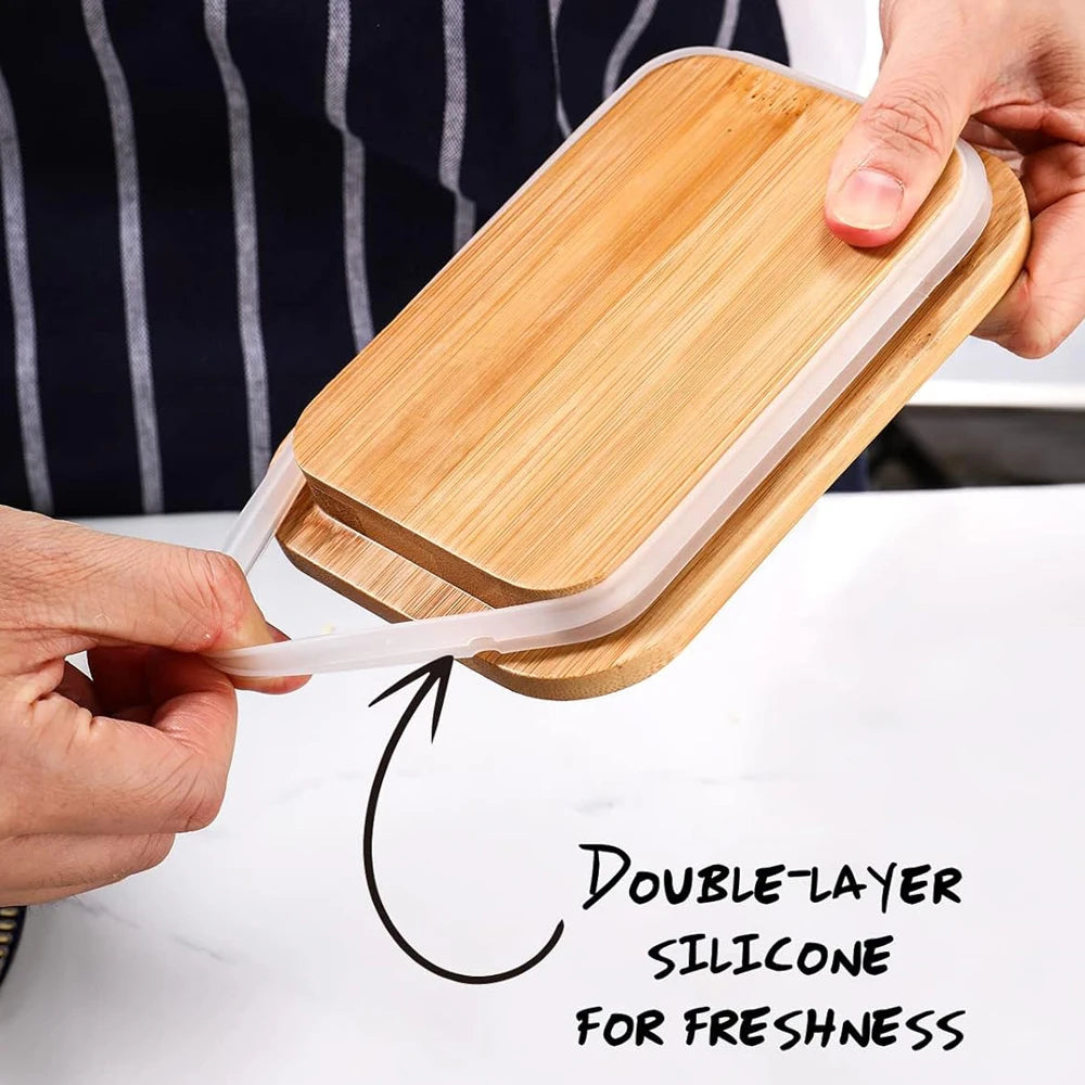 Une main tient un pot à beurre en bois avec un couvercle silicone, montrant sa conception à double couche pour la fraîcheur.