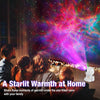A family watches a Starlit Warmth projector light show in a dark room.
