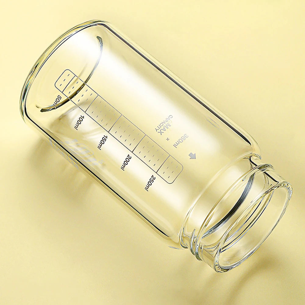Une tasse en verre transparent avec des marques de mesure et une balance sur un fond clair.
