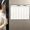 Monatlicher Planer-Kalender mit Wochentagen und Rasterfeldern auf dem Kühlschrank