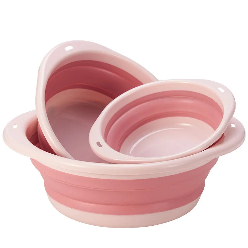 Una pila de una cubeta portátil plegable para la ropa de color rosa.