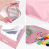A pink jewelry display pouch set with clear plastic windows is shown in various angles.