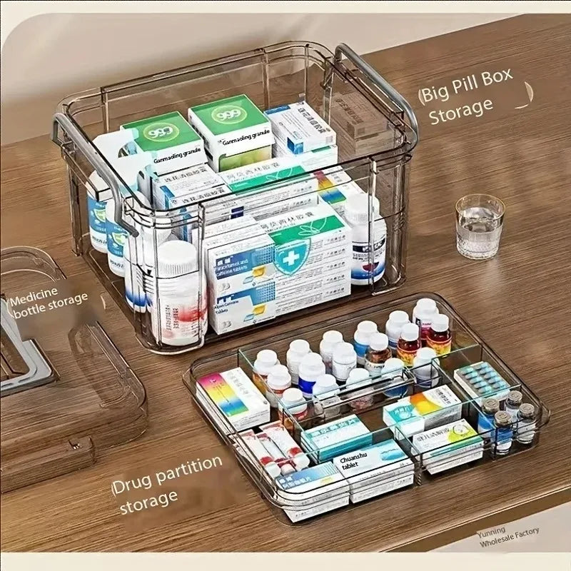Transparente Plastik-Erste-Hilfe-Box mit Griff neben verschiedenen Medikamentenflaschen und Pillenboxen auf einem Woo