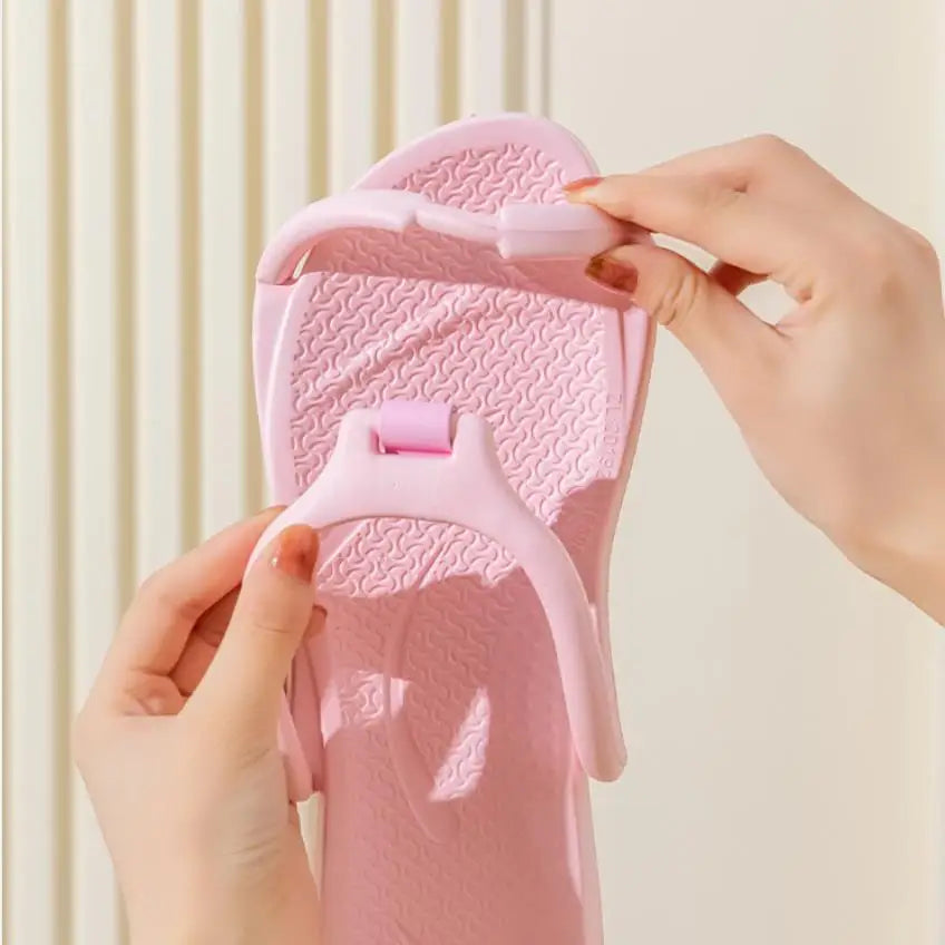Une main tient une sandale de rechange rose et pliable en EVA, montrant la texture et la sangle.