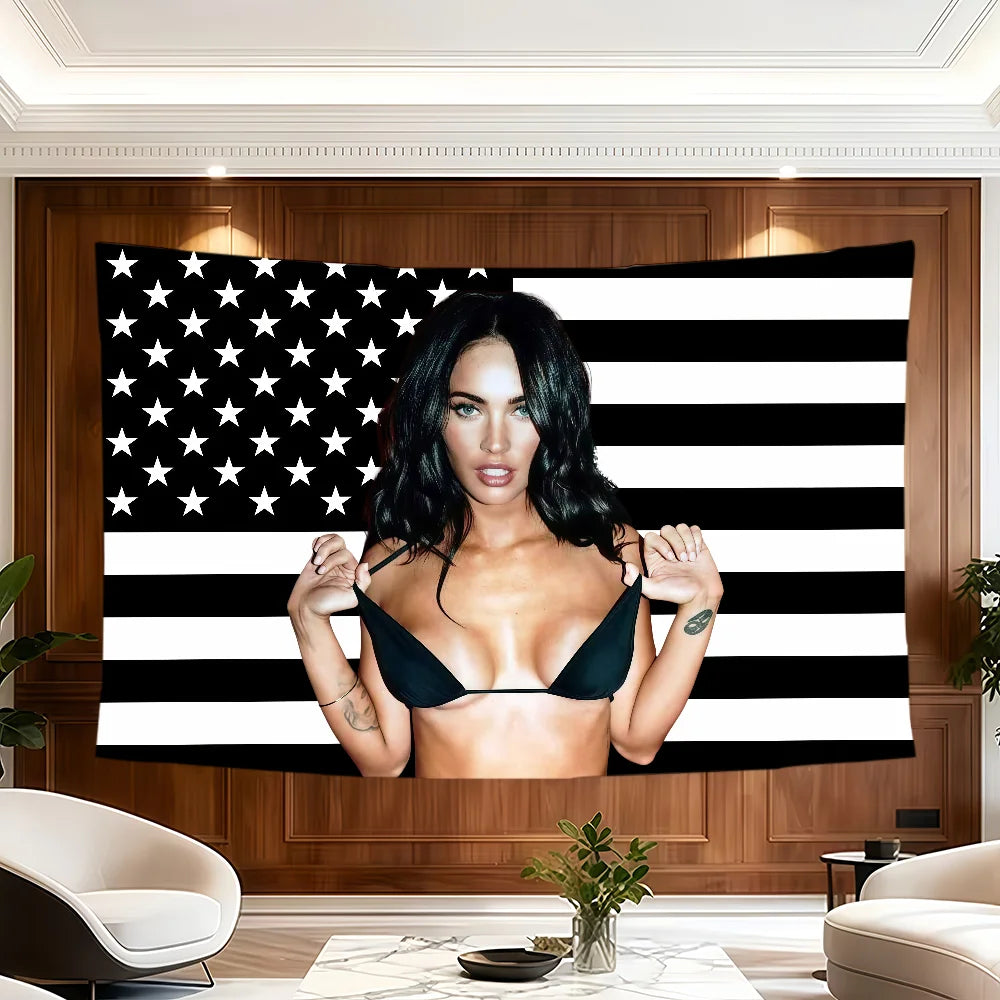 A woman posing in front of a black and white striped American flag banner.