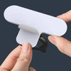 A hand is lifting a white silicone self-adhesive cabinet door handle lifter.