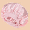 A pink satin wide brim shower cap folded and displayed on a neutral background.