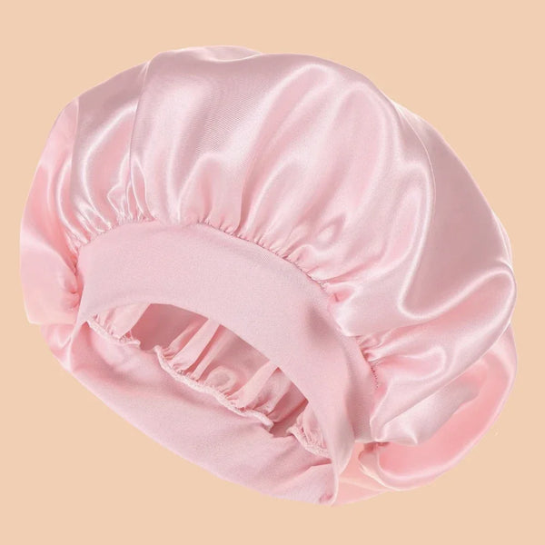 Rosa Satin-Duschhaube mit breiter Krempe, gefaltet und auf neutralem Hintergrund.