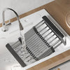 Extendable stainless steel sink drain basket with a faucet pouring water into the drain.