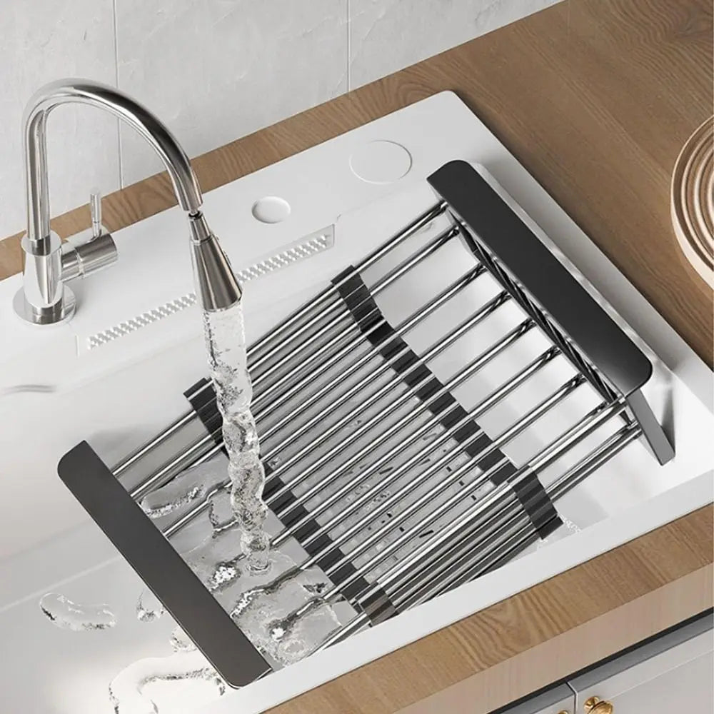 Extendable stainless steel sink drain basket with a faucet pouring water into the drain.