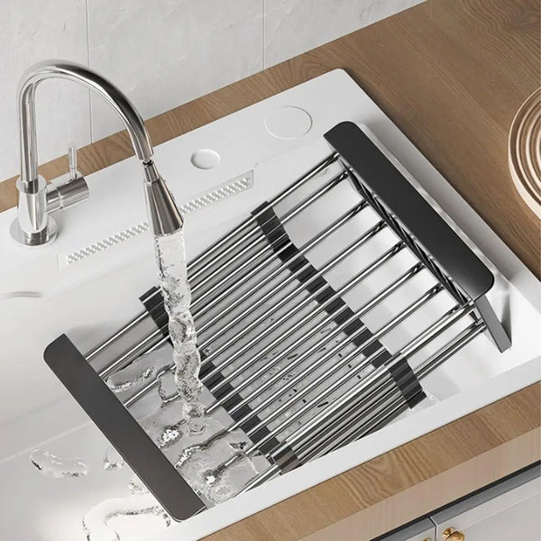Extendable stainless steel sink drain basket with a faucet pouring water into the drain.