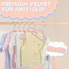 A multi-pack of premium velvet anti-slip hangers for children hanging various colored clothing on a wooden rack.