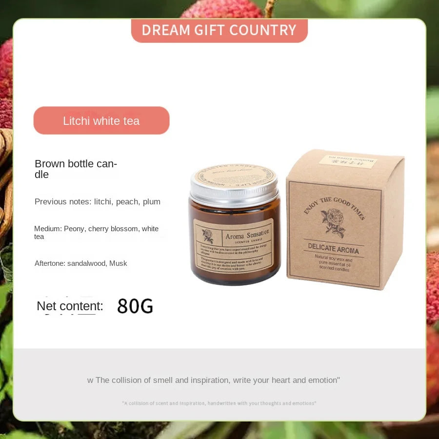 A brown glass jar candle labeled Litchi white tea with a cardboard box in the background