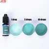 A set of liquid candle dye drops in green color shown next to dropper bottles and ceramic dishes.