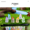A collection of luminous resin mini fairy gnomes in various pastel colors displayed on green grass.