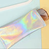 A translucent iridescent PU leather squeeze case for eyeglasses resting on a light blue surface next to sunglasses.