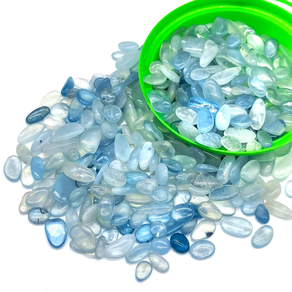 Colección de cristales de cuarzo translúcidos azul claro y transparente en un tazón verde y esparcidos sobre una superficie b
