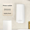 A white portable soap bar grinder with a press outlet and wall-mount design is shown next to a white toilet bowl.