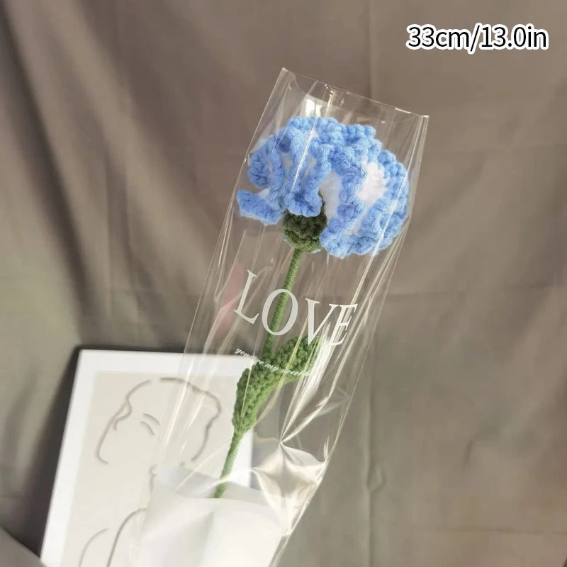 Bouquet de fleurs de carnation en coton fait main bleu et blanc dans une pochette en plastique transparent.