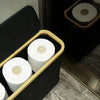 A bamboo storage basket with a lid containing white toilet paper rolls.
