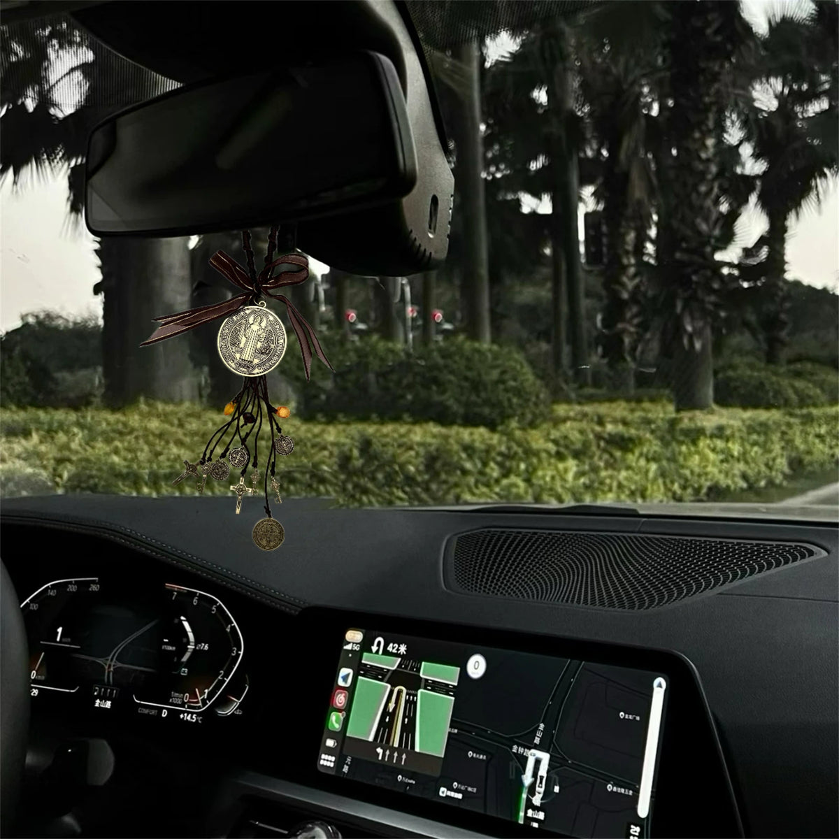 Nahaufnahme einer antiken silbernen Heiligen-Benedikt-Medaille, die an einem Band in der Auto-Innenausstattung hängt.