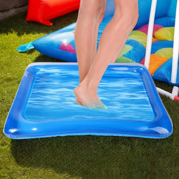 A person's bare feet are soaking in a blue inflatable foot spa basin on green grass.