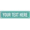 A rectangular teal metal sign with the text YOUR TEXT HERE in white capital letters.