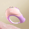 A pink and purple adjustable baby bath shampoo shield cap is shown against a soft pink background.