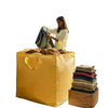 A woman is placing clothing into a yellow heavy-duty waterproof storage bag.