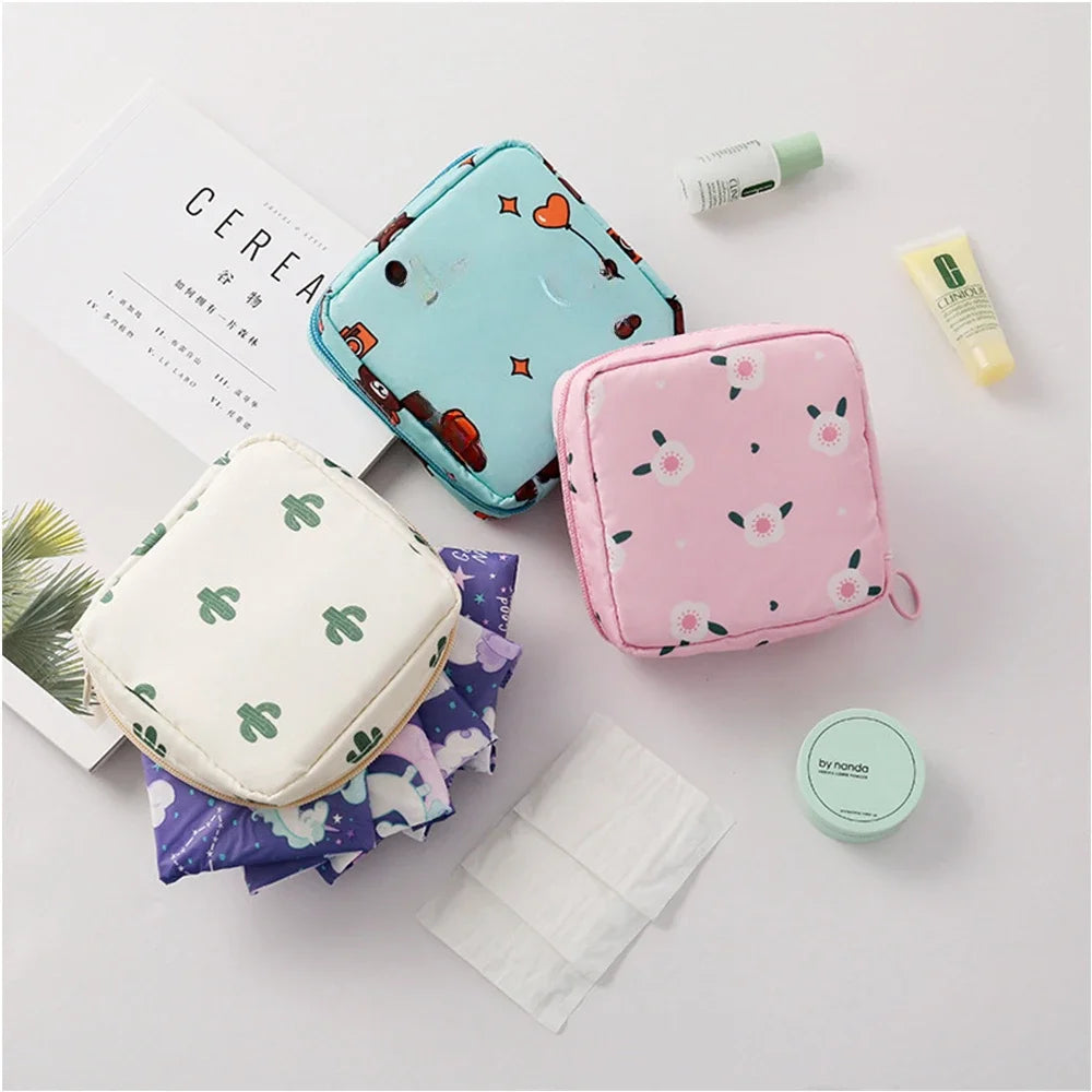 A pink floral nylon sanitary pad storage pouch next to a white pouch and some skincare products.