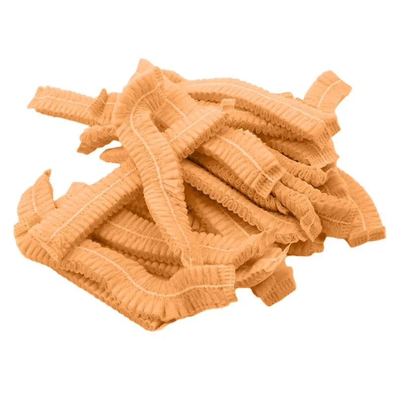 A pile of tan disposable microblading hair net caps for permanent makeup.