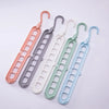 A set of five collapsible rotating clothes hangers in various pastel colors, including pink, gray, white, green, and light bl
