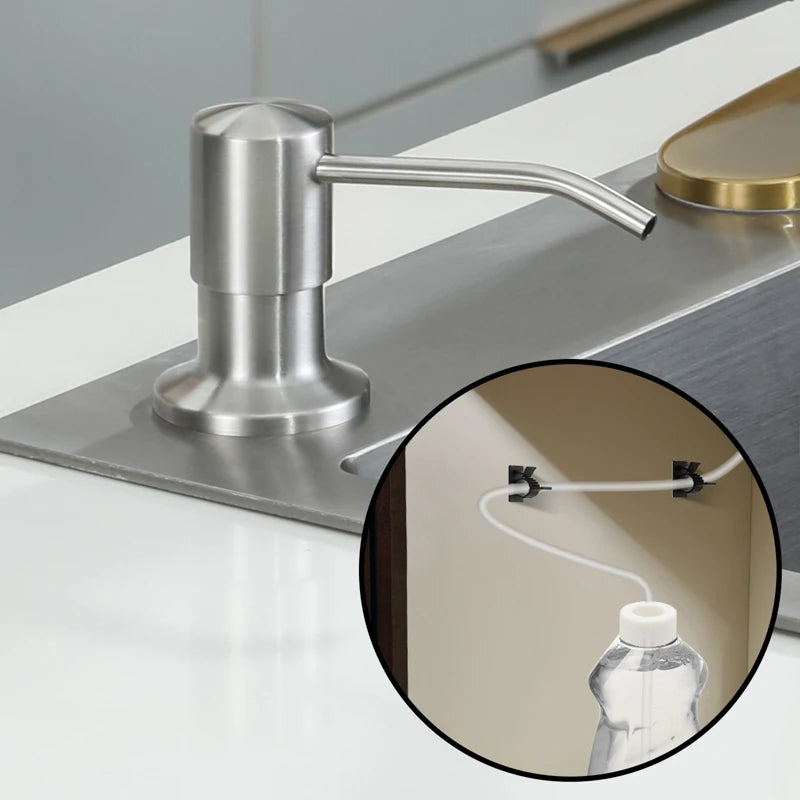 A stainless steel liquid soap dispenser with an extension tube mounted on a modern countertop.