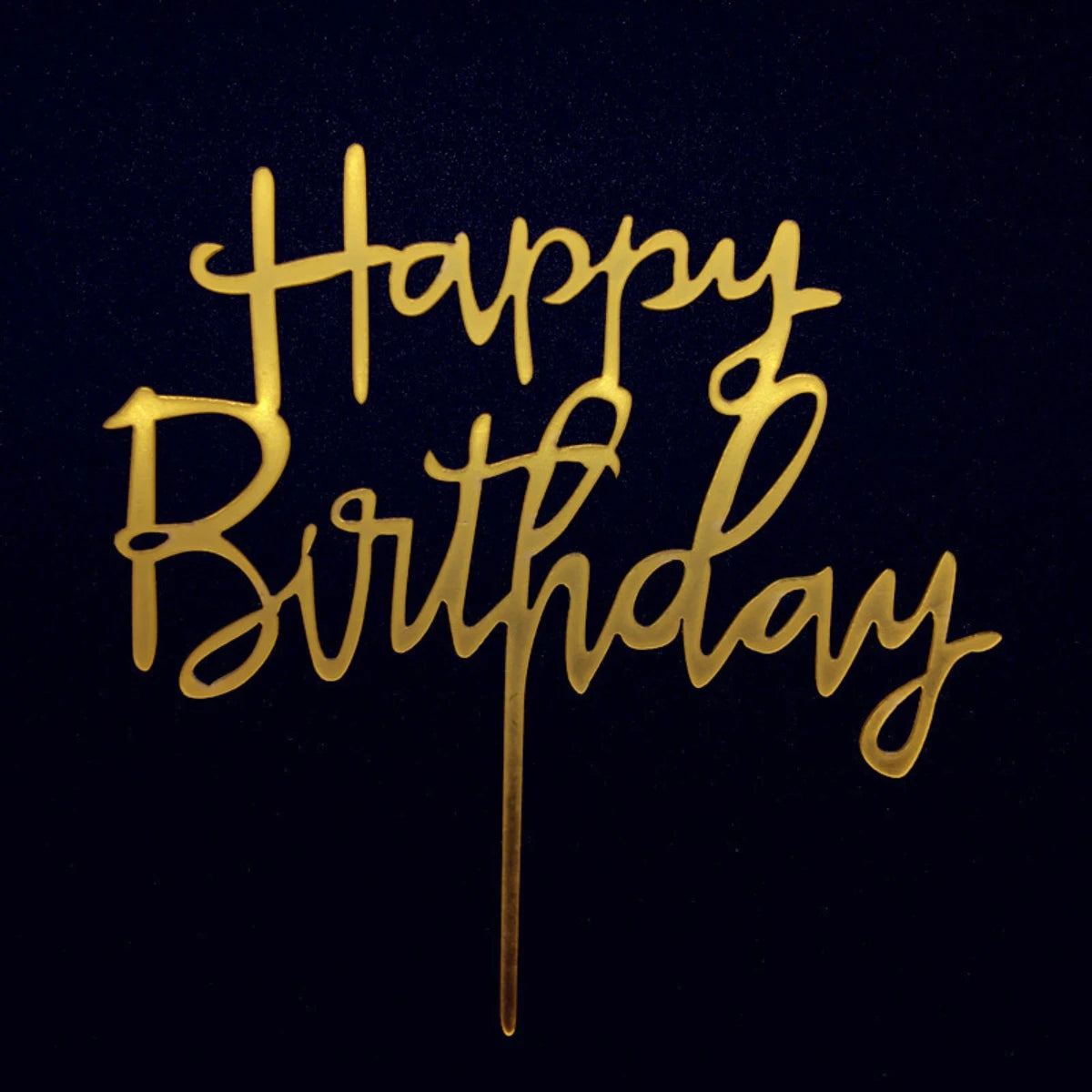 Gold acrylic birthday topper script text on a dark background
