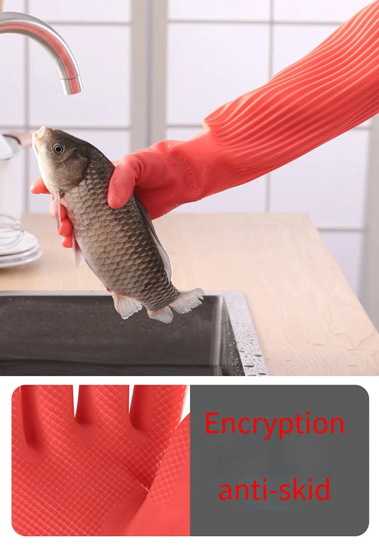 A hand wearing an orange silicone dishwashing glove is holding a fish on a wooden surface.